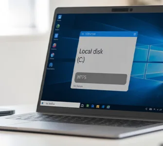 PC NTFS : image ou photo d'un ordinateur portable ouvert affichant l’écran de l’explorateur de fichiers Windows. À l’écran, on voit clairement un disque dur nommé "Disque local (C:)" avec une infobulle ou étiquette indiquant "NTFS".