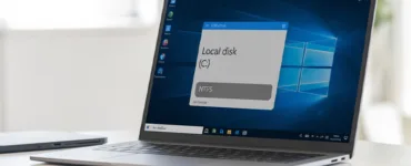 PC NTFS : image ou photo d'un ordinateur portable ouvert affichant l’écran de l’explorateur de fichiers Windows. À l’écran, on voit clairement un disque dur nommé "Disque local (C:)" avec une infobulle ou étiquette indiquant "NTFS".