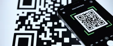 Créer un code QR : image ou photo d'un QR code en gros plan, stylisé avec un smartphone en train de scanner le QR code.