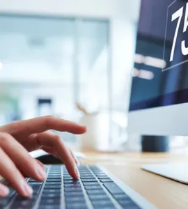 Dactylographie : image ou photo d'plan rapproché d’un clavier d’ordinateur avec des mains en train de taper rapidement, avec un léger flou de mouvement sur les doigts pour montrer la vitesse.