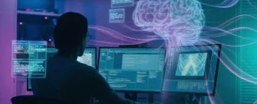 Intelligence artificielle : image ou photo d'une personne assise devant un PC dans une pièce sombre avec un éclairage néon bleu/violet. Sur l’écran, plusieurs interfaces d’intelligences artificielles flottent.