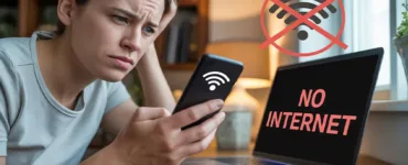 Partage de connexion : image ou photo d'une personne regarde son téléphone avec un air frustré pendant qu’un ordinateur portable affiche “No Internet”