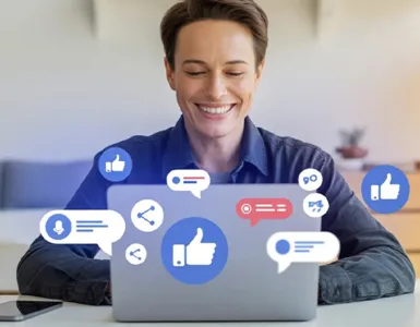 Page Facebook : image ou photo d'une personne assise avec un ordinateur portable avec des icônes Facebook (like, commentaire, partage) qui flottent autour de l’écran.