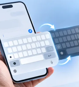 Changer le clavier d'un téléphone : image ou photo d'une main tenant un smartphone avec deux claviers virtuels superposés et des flèches symbolisant le changement de clavier sur téléphone.